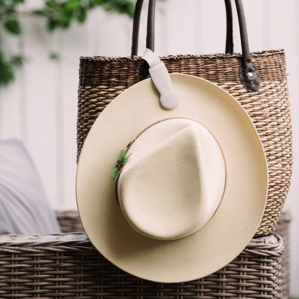 Klipsta holding hat to straw bag.